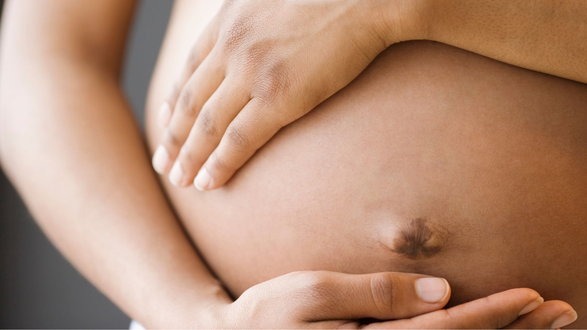 Grávida com as mãos na barriga