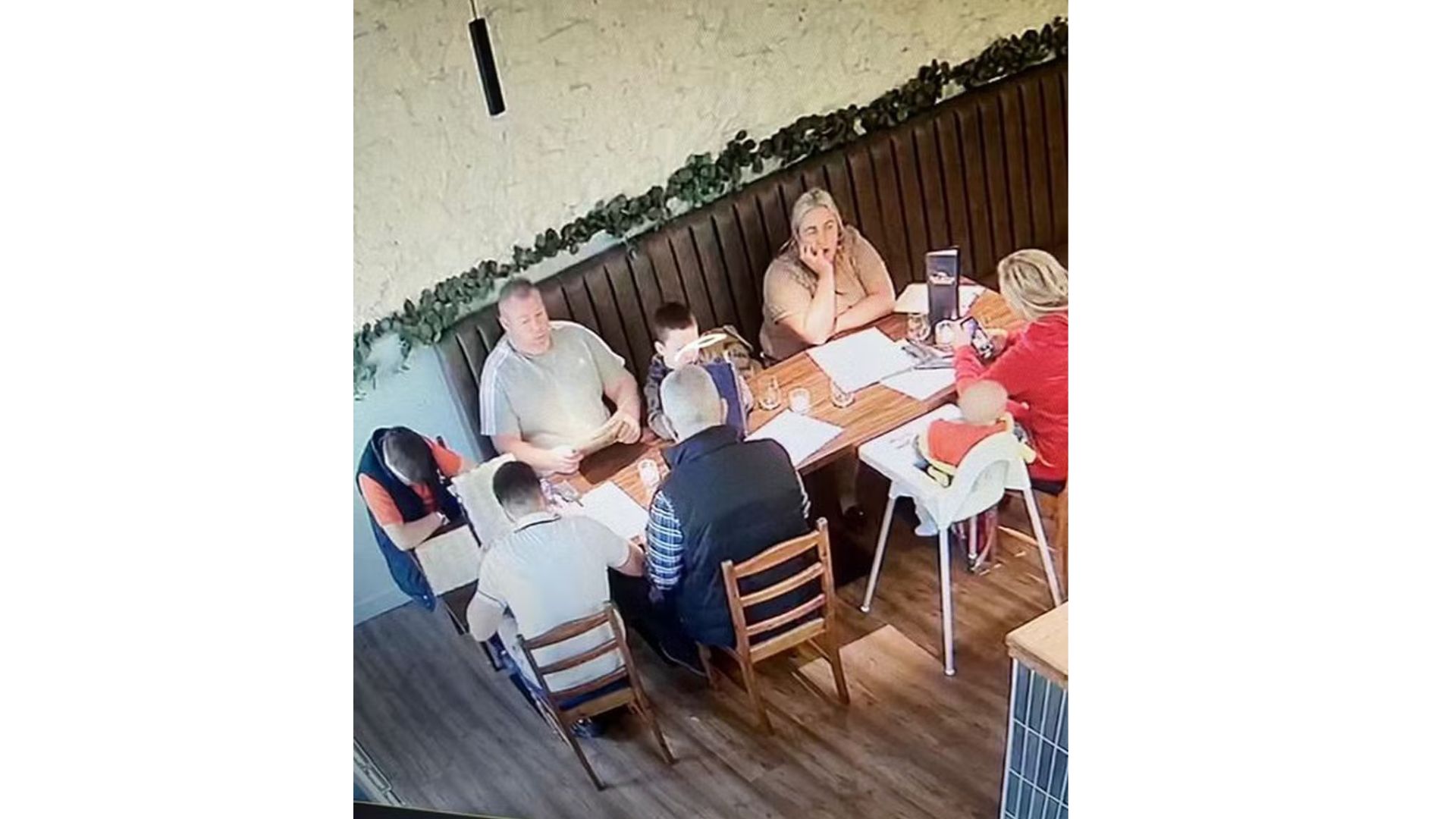 Família sentado na mesa de restaurante
