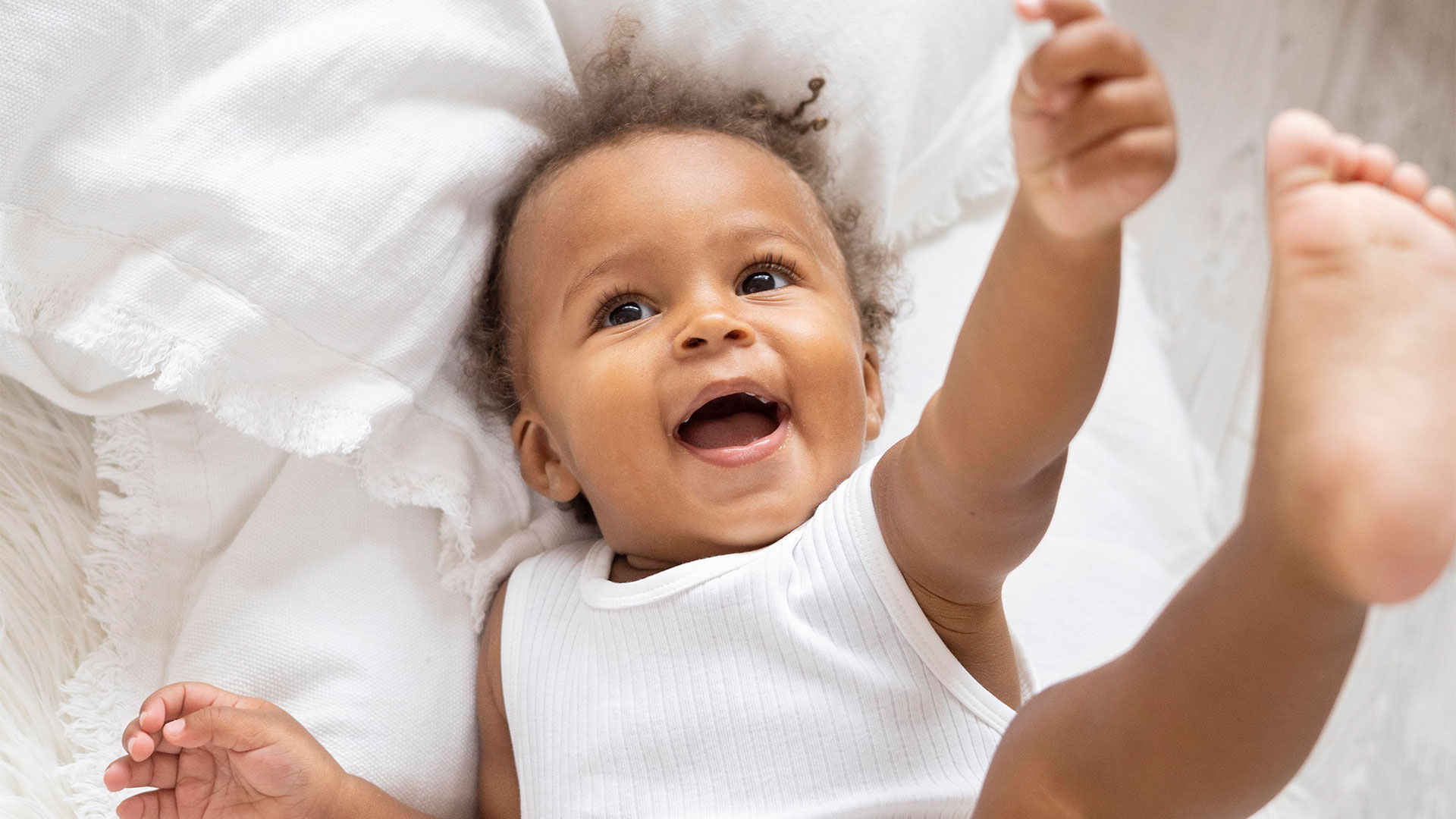 bebê sorrindo na cama