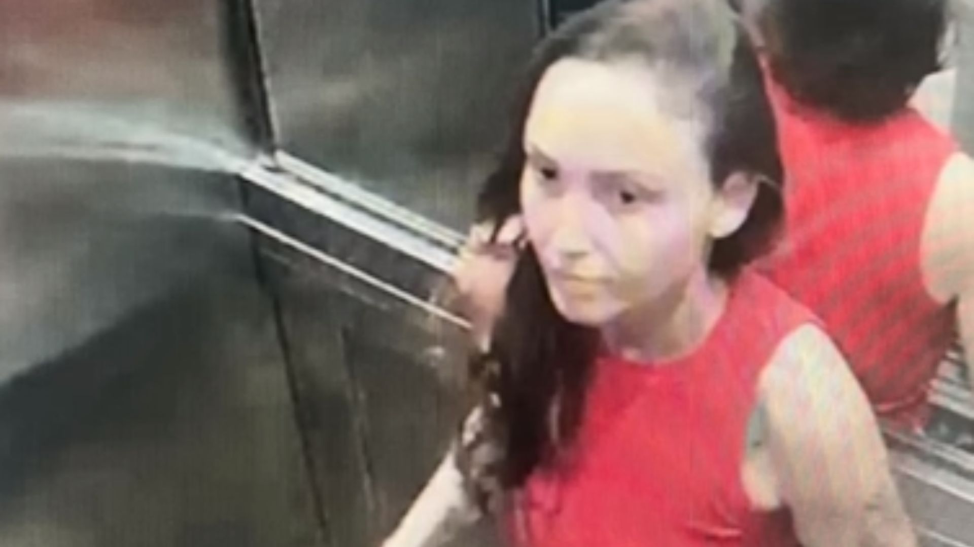 Mulher de blusa vermelha no elevador