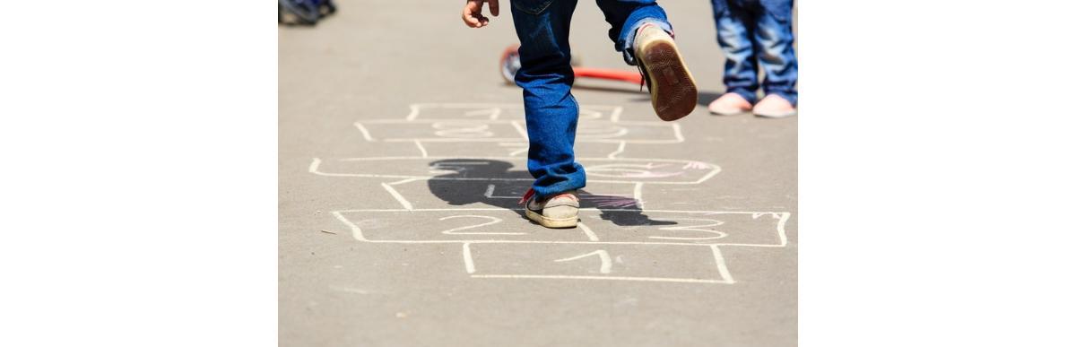 kids-playing-hopscotch-on-playground-outdoors-picture-id512047790
