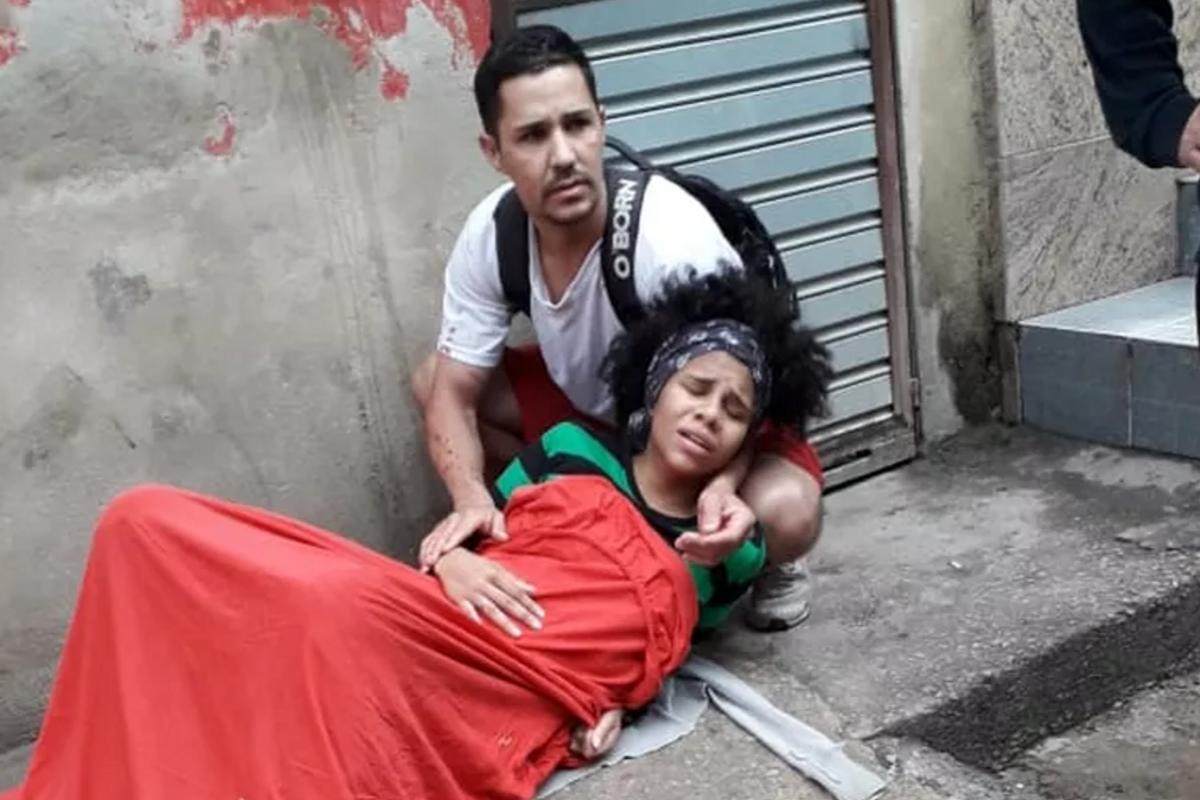 A mulher com a bebê logo depois do parto na rua