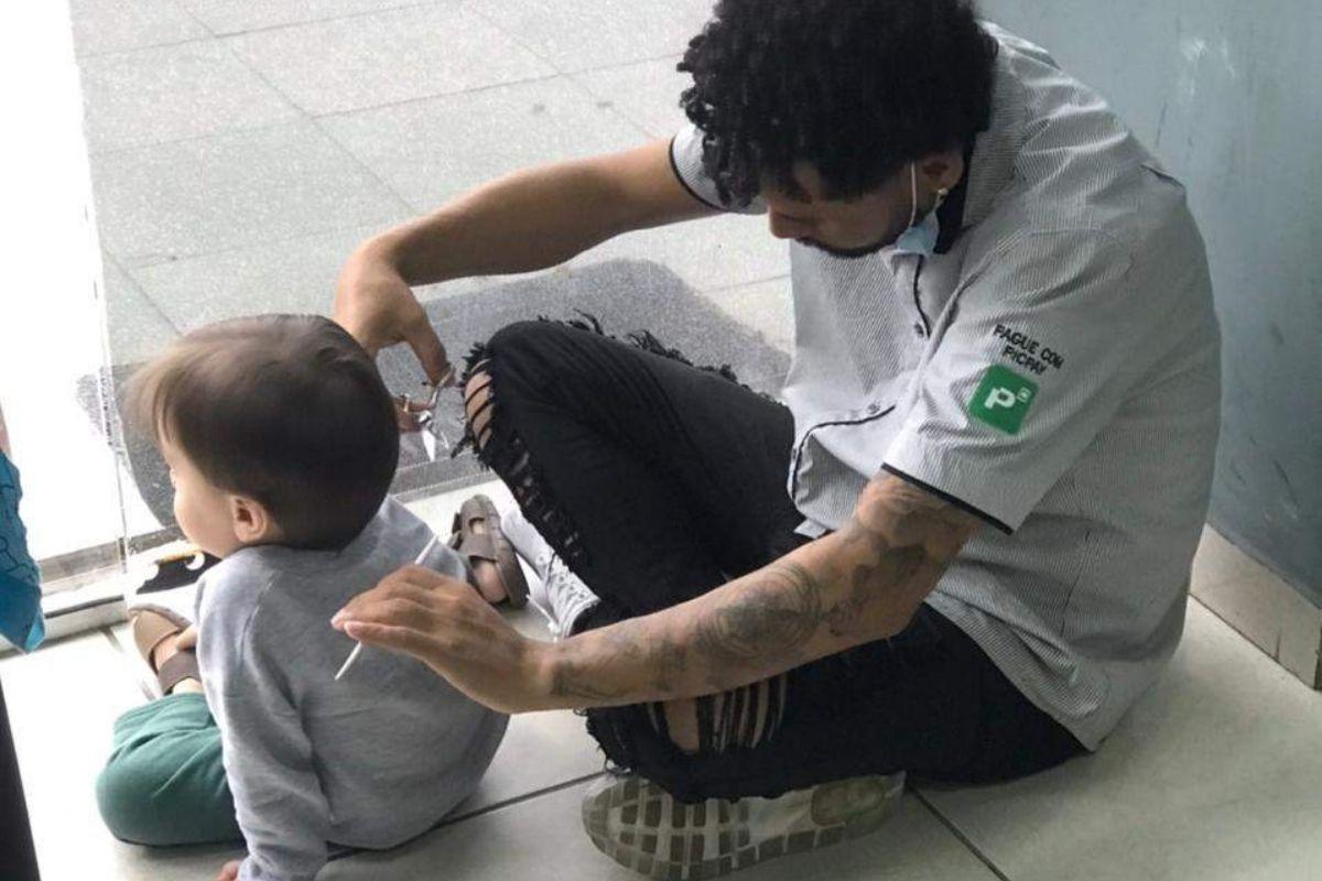 Pai corta cabelo de menino no chão