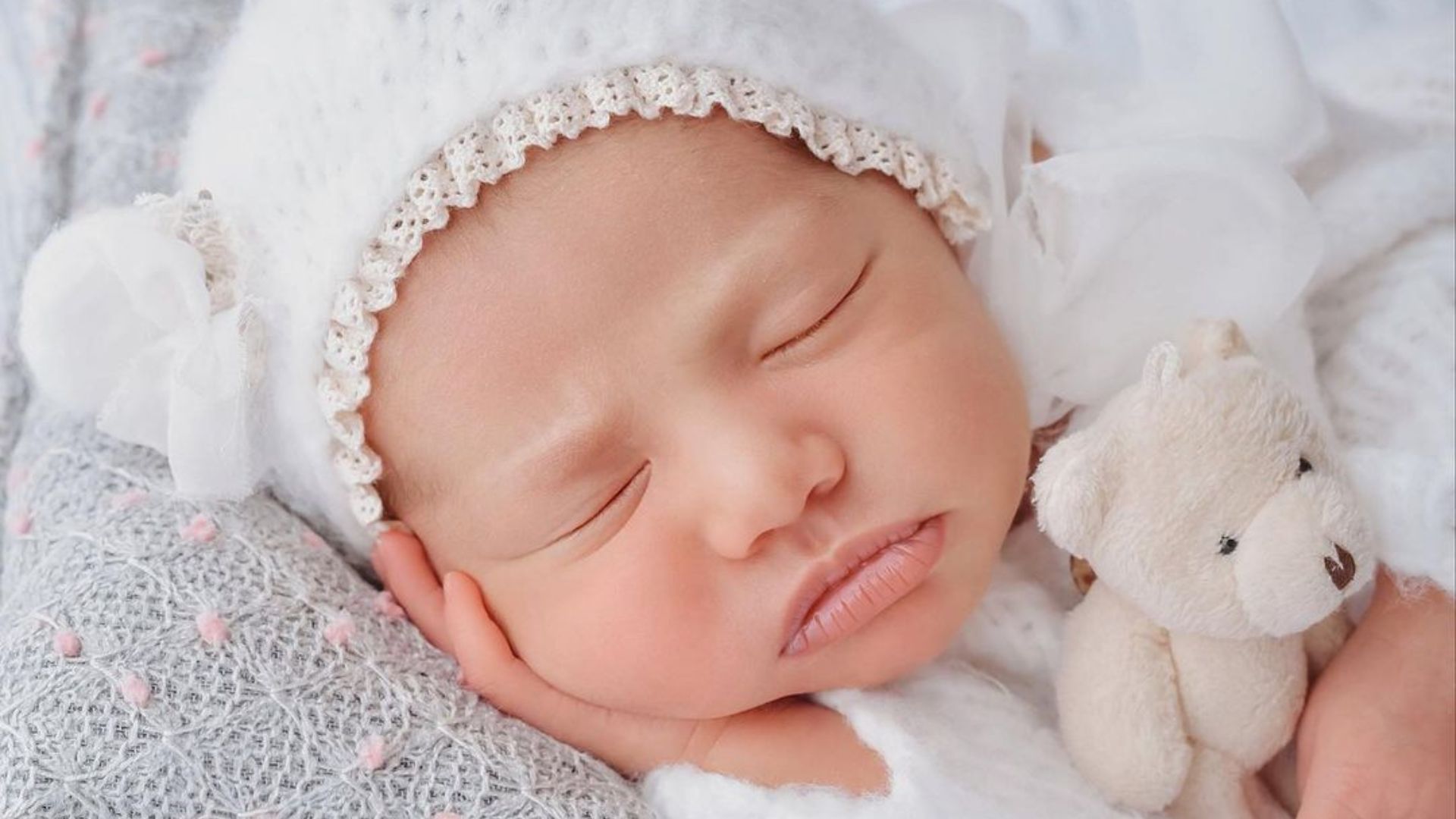 Mavie, filha de Newmar e Bruna Biancardi, dormindo apoiada em mão com touca de orelhas e abraçada a urso de pelúcia, em ensaio 'newborn' fotografado por Ingryd Alves