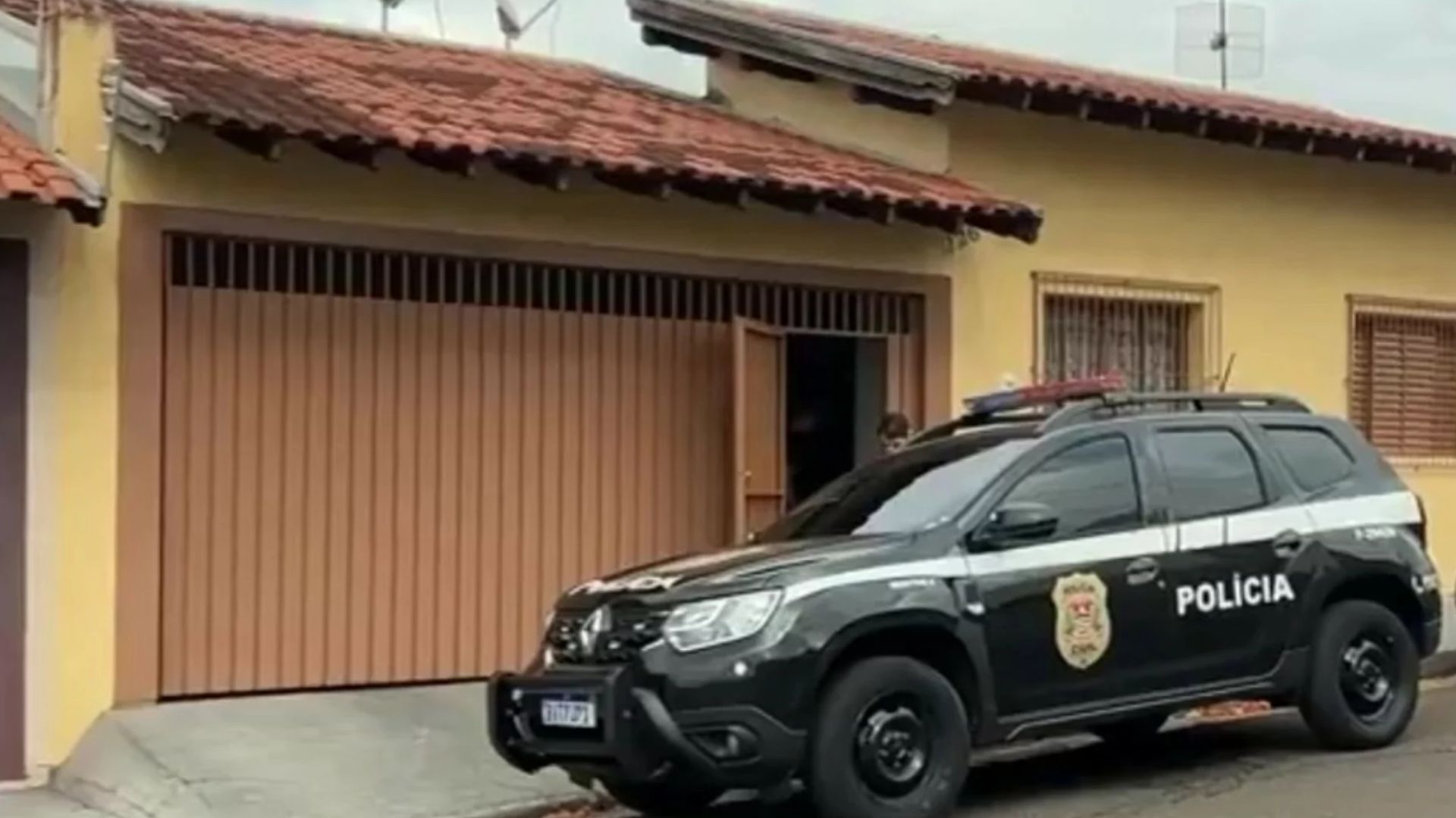 Frente de casa e carro da polícia