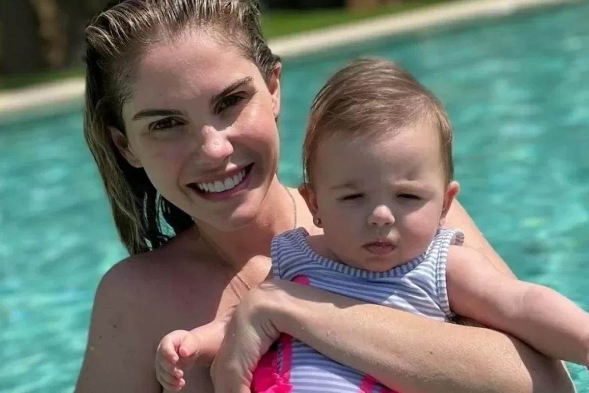 Mãe com bebe no colo na piscina