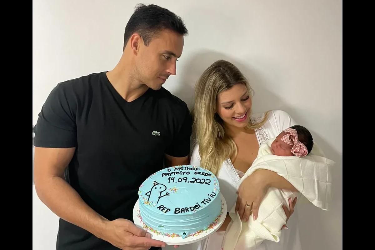 Homem de preto e mulher de nranco com bebe de colo