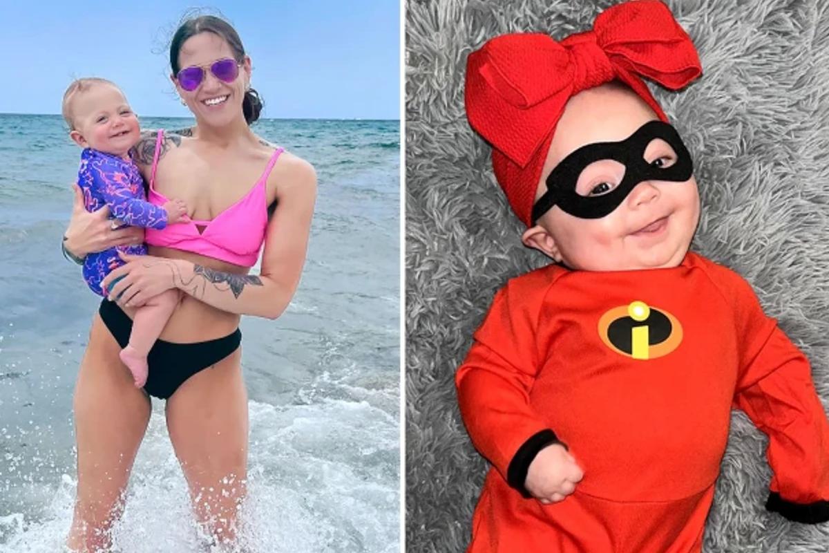 Mulher branca com bebê de colo. Bebê vestida com fantasia vermelha dos íncriveis