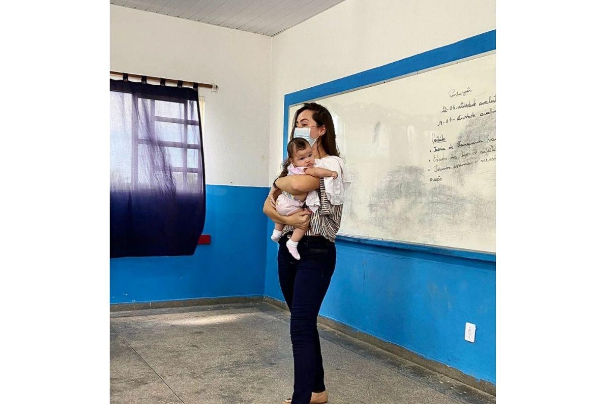 A professora Bruna Porto com Maria Alice, filha de aluna, no colo