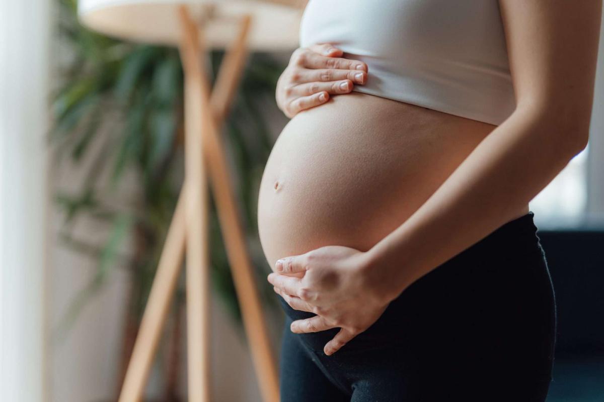 Mulher grávida segurando sua barriga