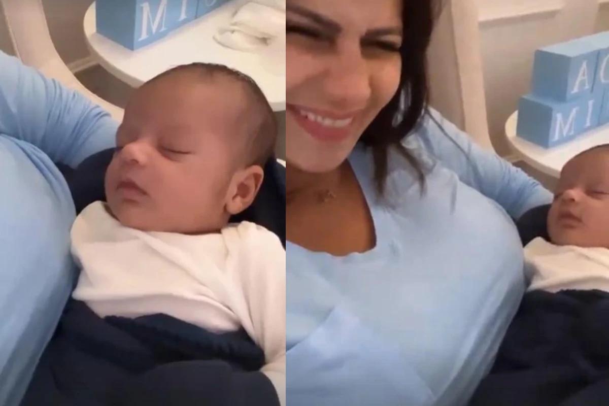 Mulher com clusa azul com filho no colo