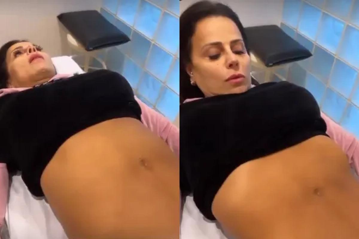 Viviane Araujo deitada enquanto mostra sua barriga depois de 23 dias do parto