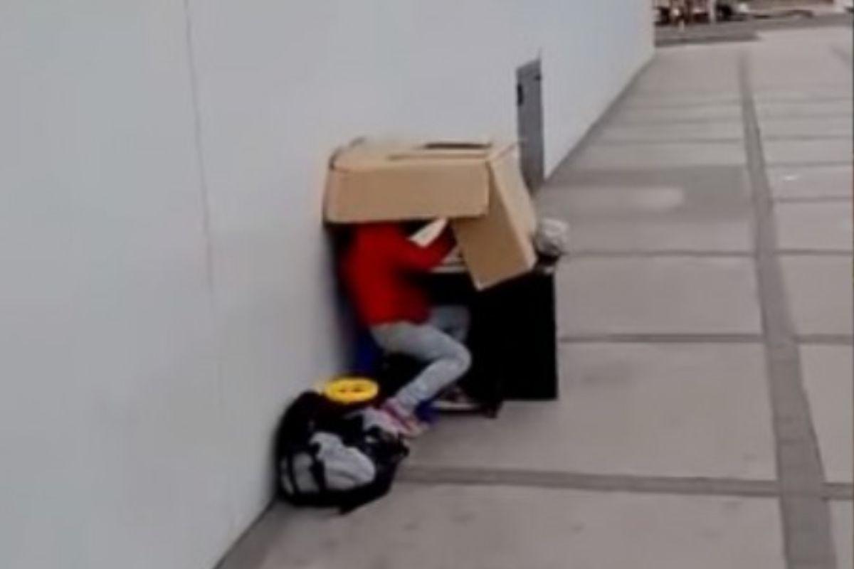 A menina estava estudando com uma mesa de papelão improvisada pelo pai