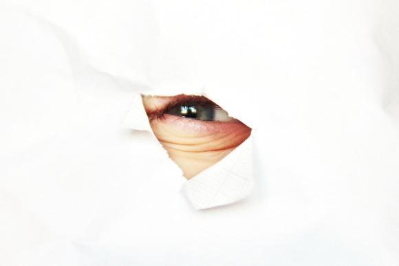 a-hole-in-the-paper-with-a-children-eye-picture-id696217070