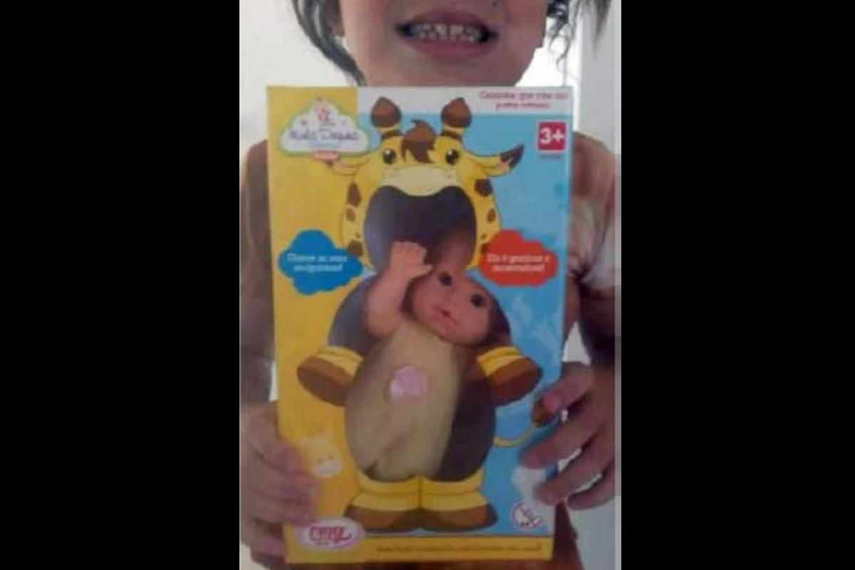 Menina com sorriso segurando boneca