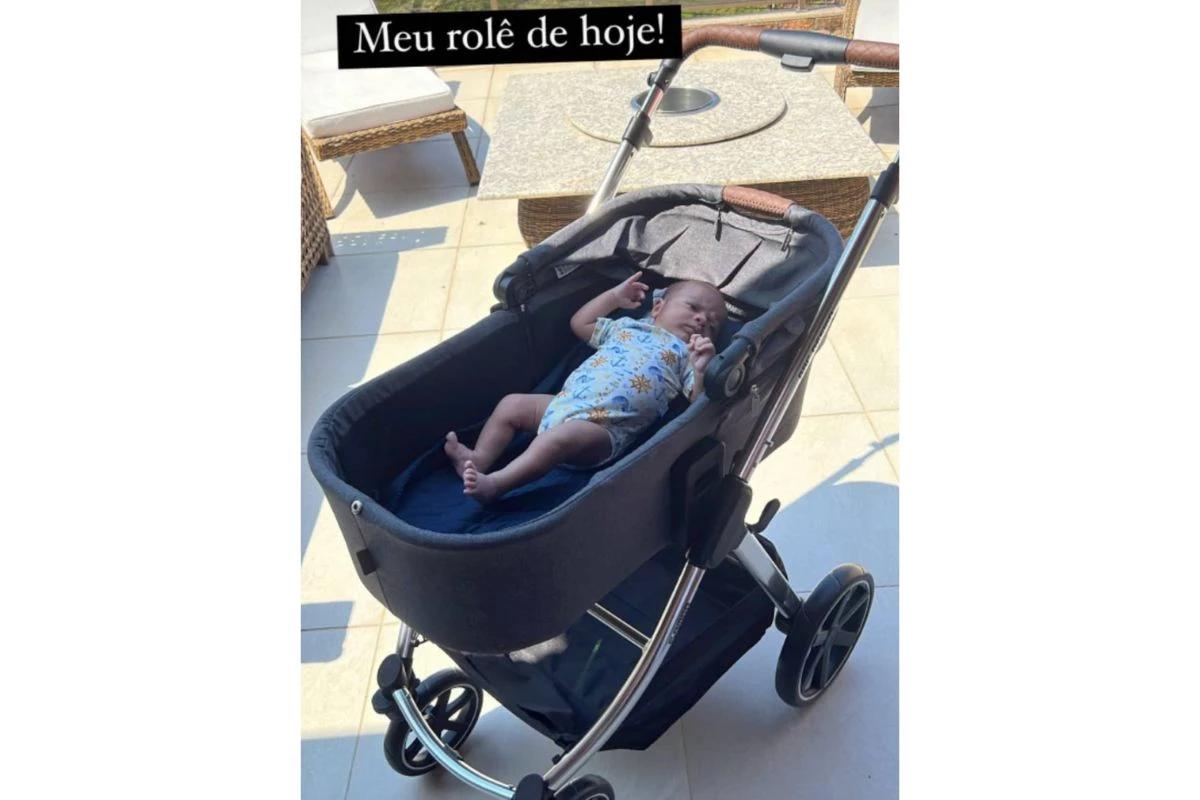 Filho de Viviane Araújo deitado em carrinho de bebê tomando sol