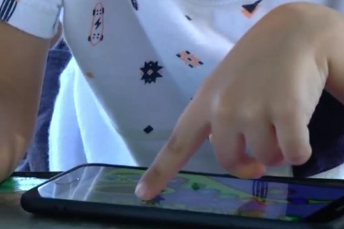 Bryan, de 3 anos de idade, brincando no celular