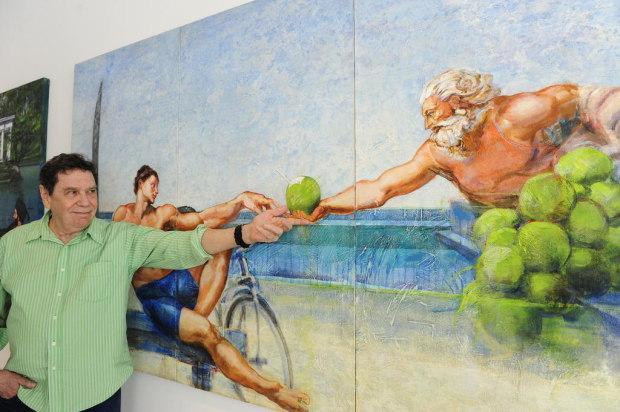Lielzo Azambuja ao lado de uma de suas obras, 'A Criação de Adão', de Michelangelo, ambientado na Praia do Pepê.