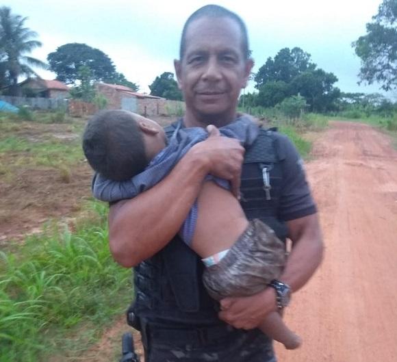 Policial segurando um dos irmãos | Foto: Reprodução / G1 / Gerência de Operações Especiais (GOE)