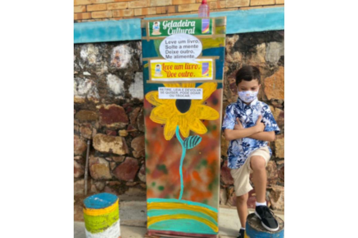 Criança transforma geladeira velha em prateleira de livros