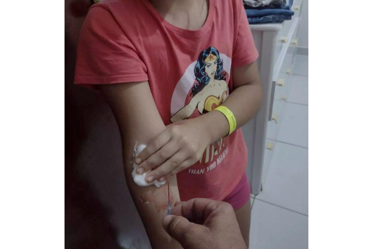 O pai felizmente conseguiu remover a agulha no braço da filha sem que machucasse mais ela