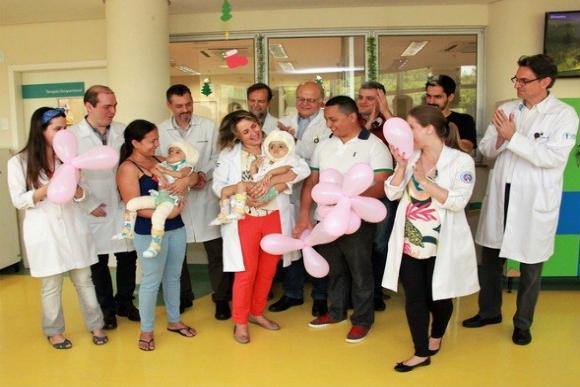 Equipe médica com irmãs no momento da alta hospitalar. (Foto: Divulgação/HC de Ribeirão Preto)