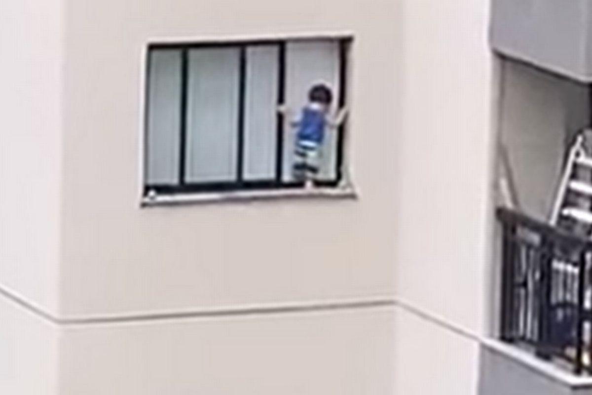 O menino estava brincando no parapeito da janela