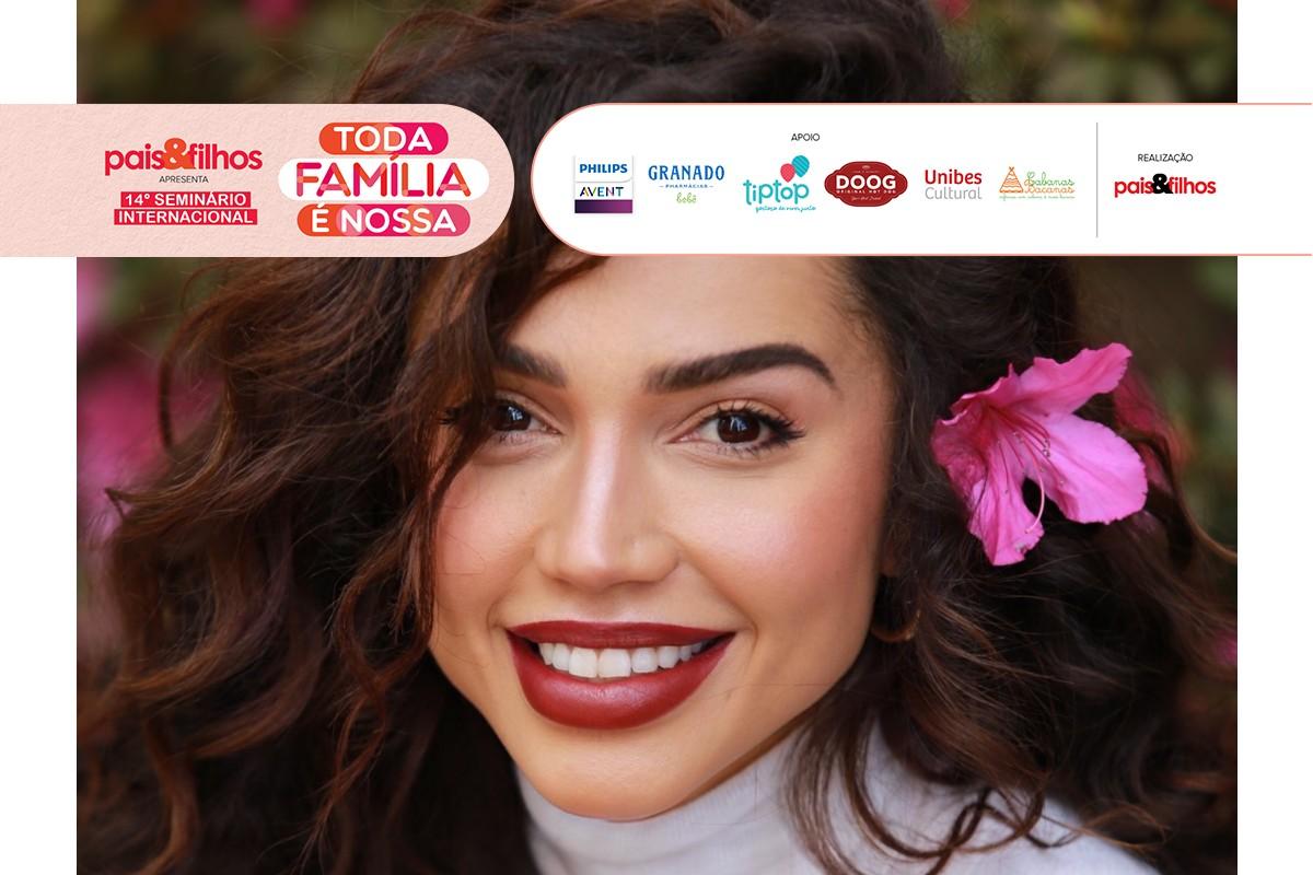 Paula Amorim com flores no cabelo sorrindo