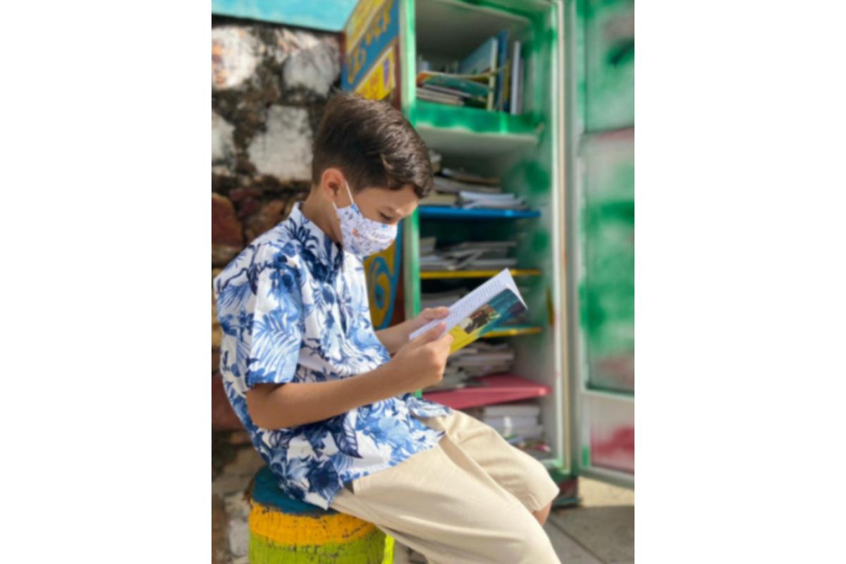 Criança transforma geladeira velha em prateleira de livros