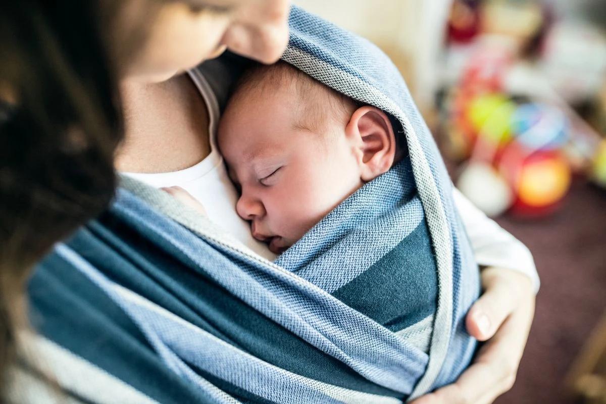 Bebê dormindo no colo da mãe