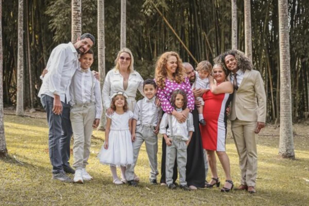 Família, em um parque, no batizado de 5 crianças