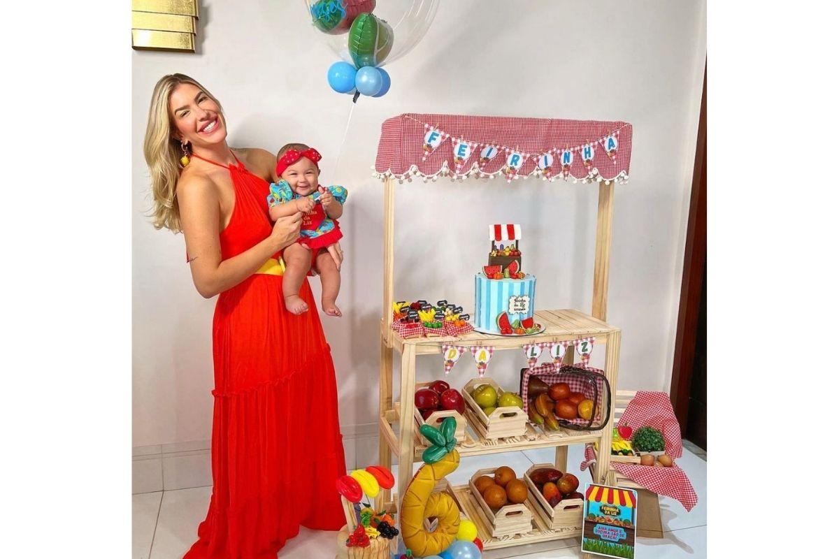 Lore posa em foto com a filha para comemoração dos 6 meses na "Feirinha da Liz"