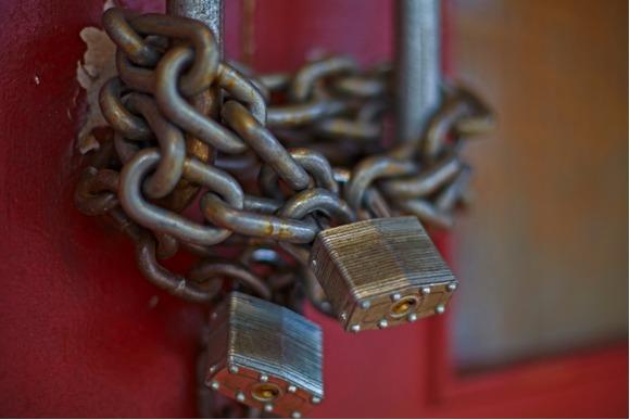 chain-and-locks-on-doors-of-closed-business-picture-id595351766