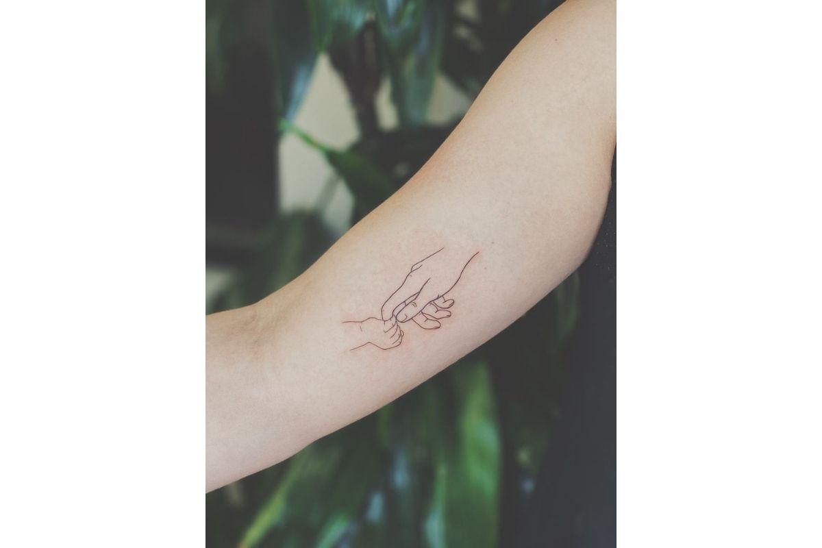 Tatuagem para filho com desenho de mão