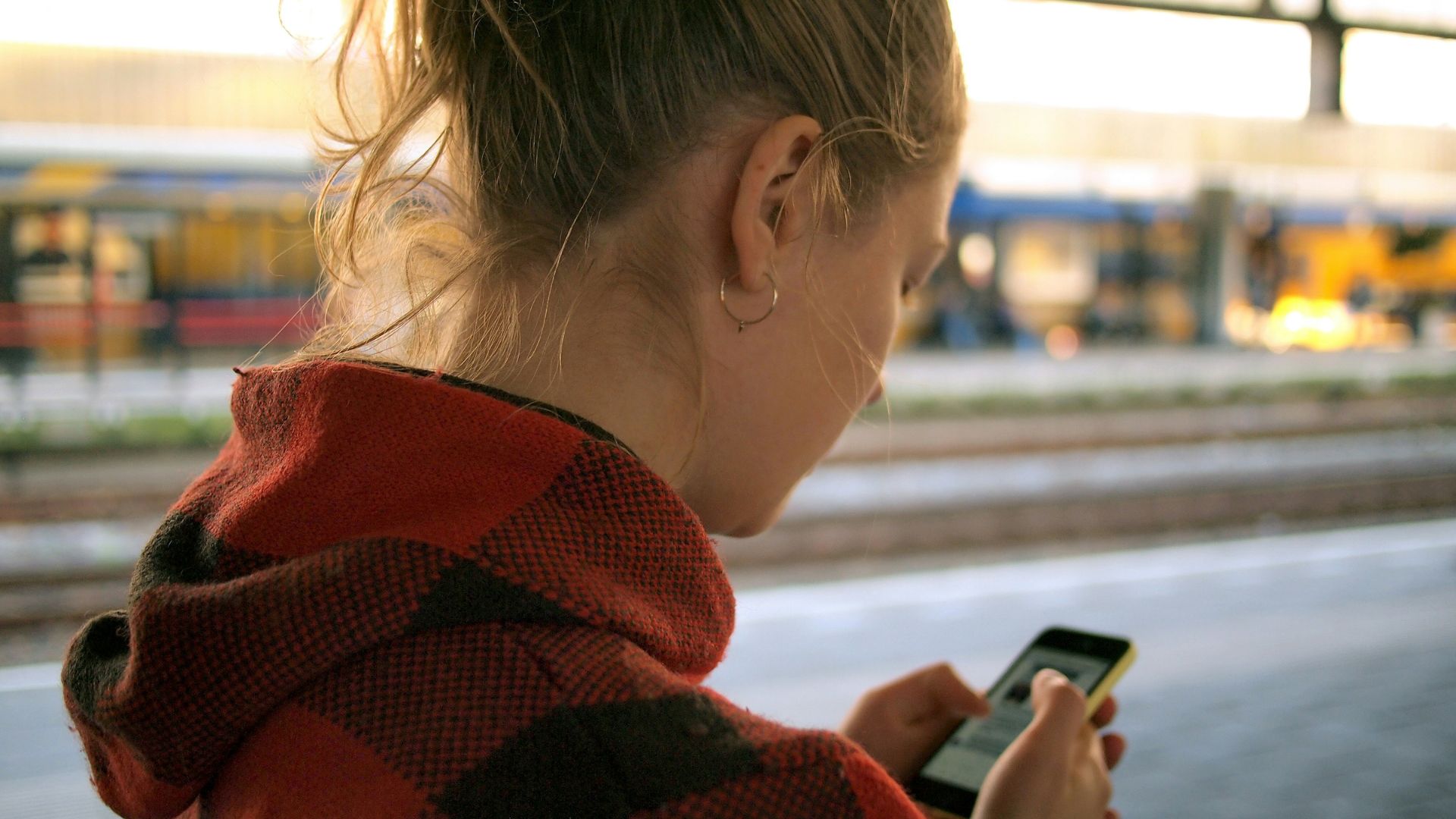 Adolescente com celular na mão