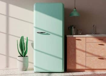 Geladeira azul em uma cozinha com pia, armários, luminárias e plantas.