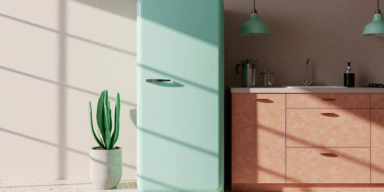 Geladeira azul em uma cozinha com pia, armários, luminárias e plantas.