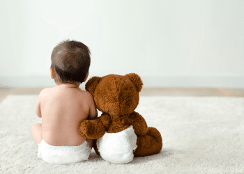 bebe e seu ursinho sentados de costas