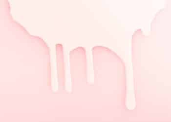 Leite derramado em um fundo rosa, representando a amamentação.