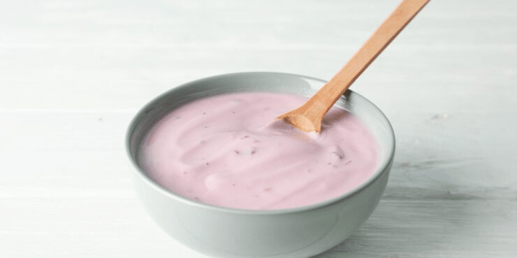 Bowl com uma colher apoiada. Dentro tem danone rosa