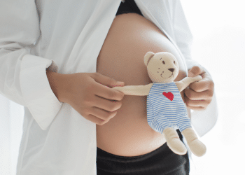 Barriga de grávida com um ursinho na frente.