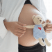 Barriga de grávida com um ursinho na frente.