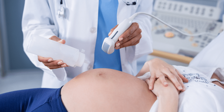 Profissional de saúde exercendo um exame em uma mulher grávida