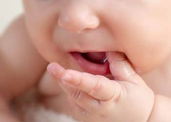 Close da boca de um bebê, destacando os movimentos orais importantes para o desenvolvimento da fala.