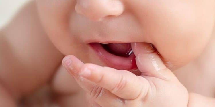 Close da boca de um bebê, destacando os movimentos orais importantes para o desenvolvimento da fala.