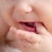 Close da boca de um bebê, destacando os movimentos orais importantes para o desenvolvimento da fala.