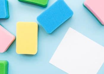 Esponjas de limpeza coloridas em um fundo azul claro.