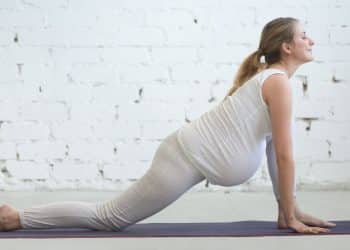 Mulher grávida em posição de yoga
