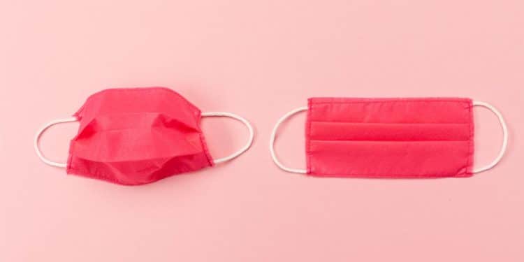 Máscaras vermelhas de resfriado em cima de um fundo rosa.