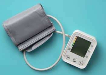 Medidor de pressão arterial em fundo azul, representando a pré-eclâmpsia na gravidez.